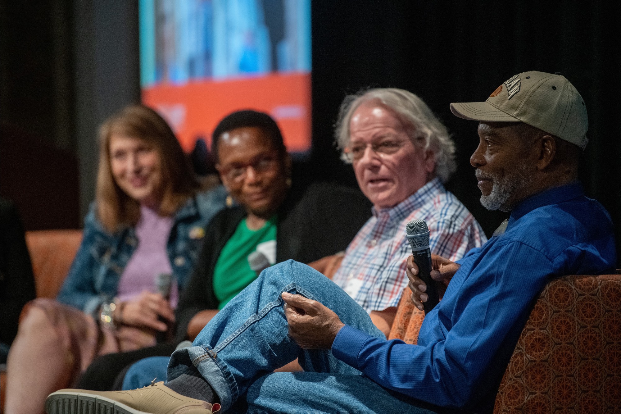 Four panelists, one talking with a microphone
